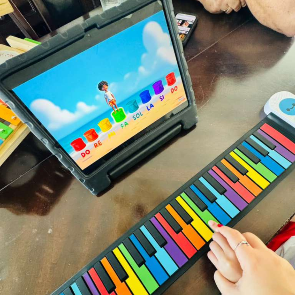 How to Help a Child with Anxiety? Child using a colorful piano and a tablet during a child music therapy session for learning and emotional development.