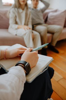 Behavioral Health Case Manager (CBHCM) A therapist takes notes while counseling a couple in an indoor session.